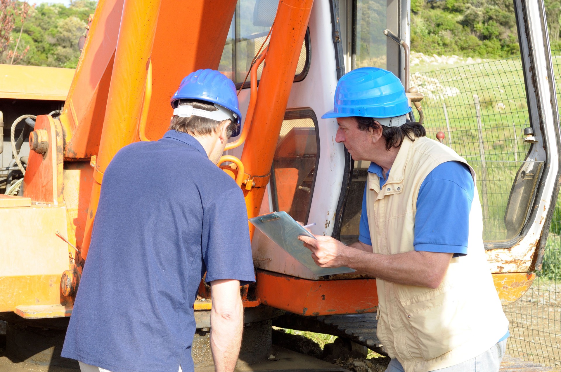 Due meccanici esame dell'escavatore
